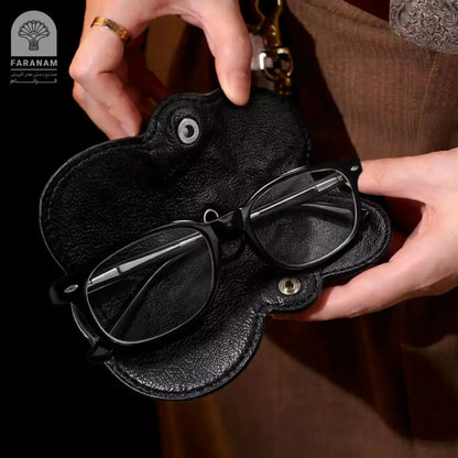 Hand holding luxury black leather sunglasses cover with glasses, Faranam sustainable accessory.