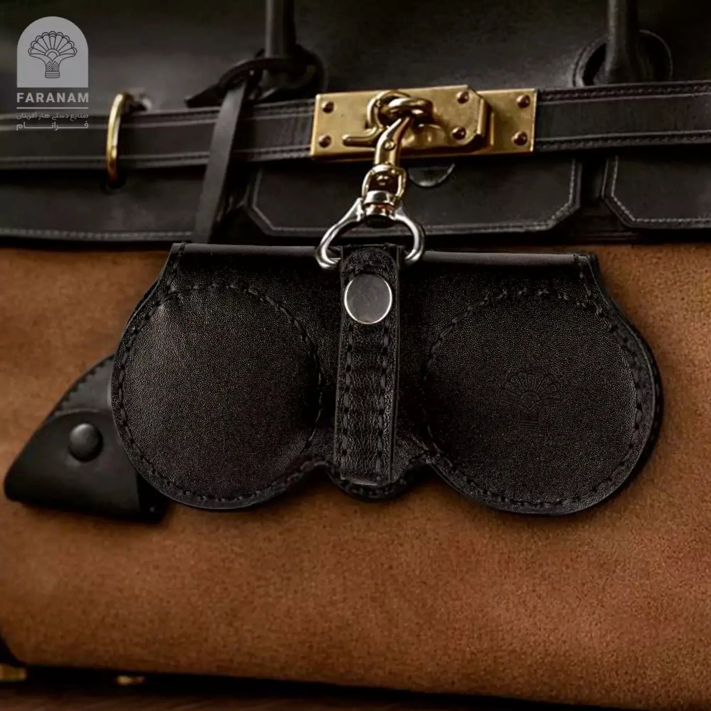 Faranam luxury Moroccan leather sunglasses cover clipped to a brown suede bag