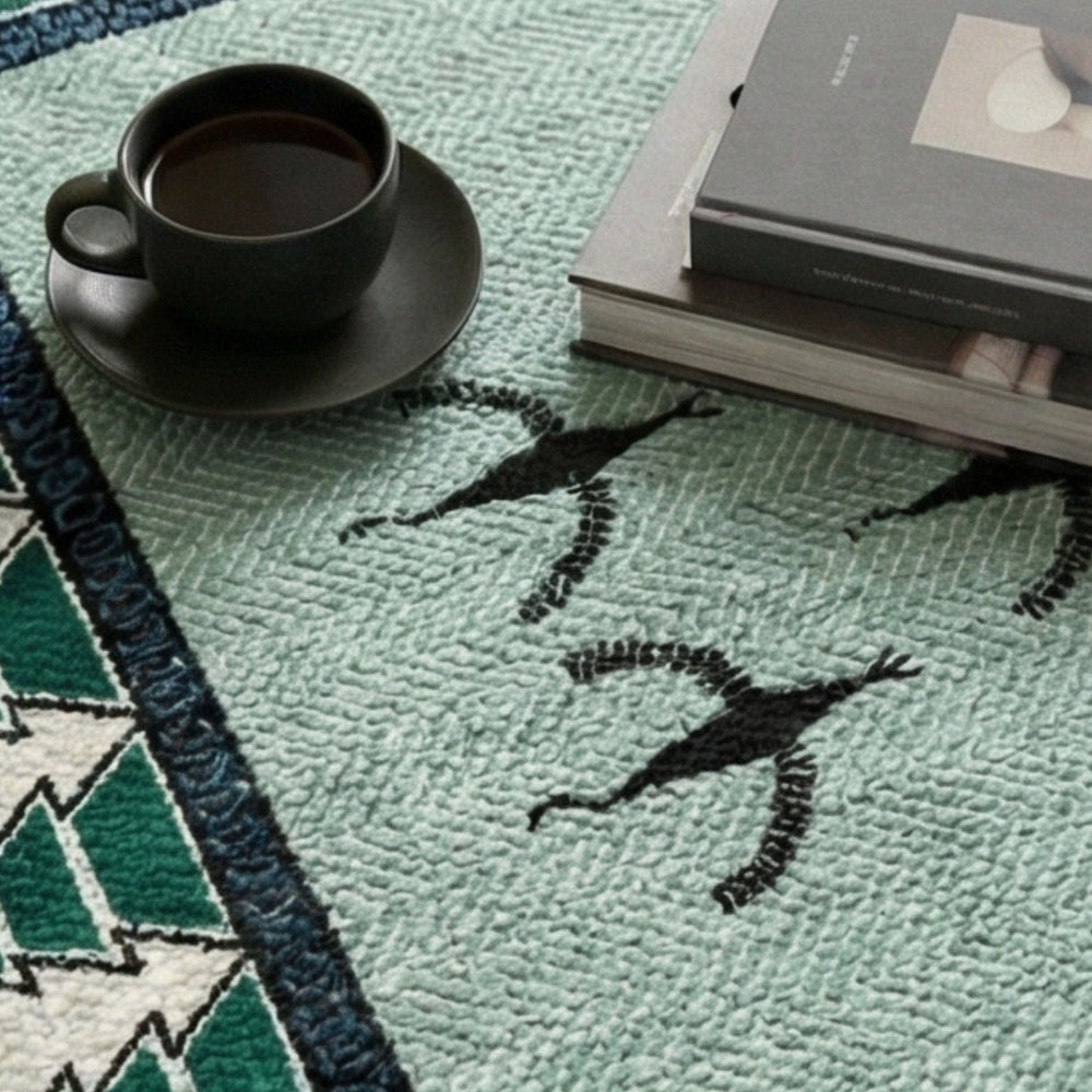 Teal rug with black geometric patterns featuring a black cup and saucer and books.
